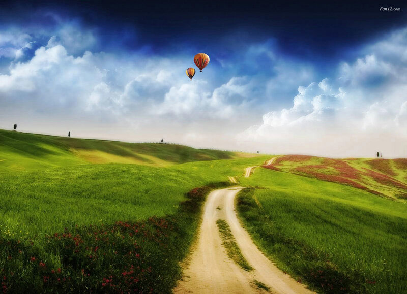 Hot air balloons over green hills