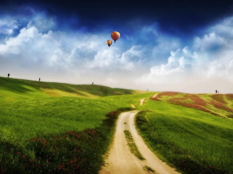 Hot air balloons over green hills