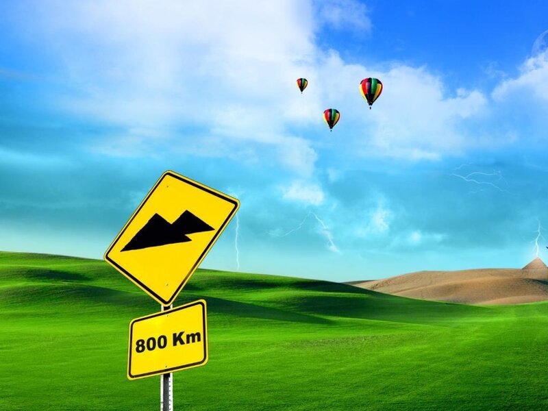 Hot air balloons over green hills