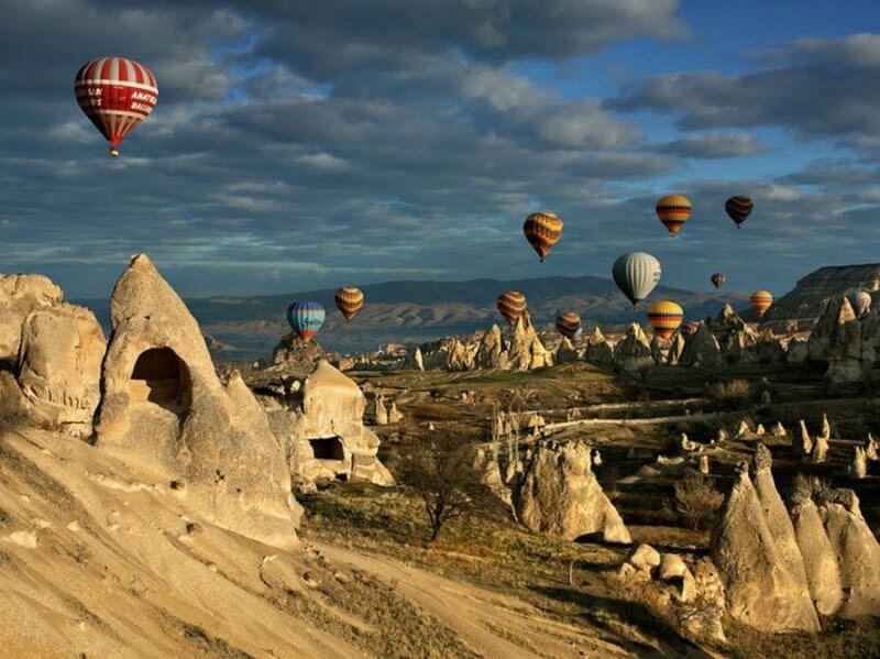 Hot Air Balloons over Rock Formations — Blue, Dramatic