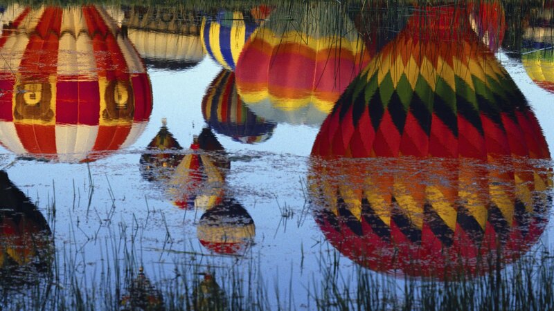 Hot air balloons reflected in water