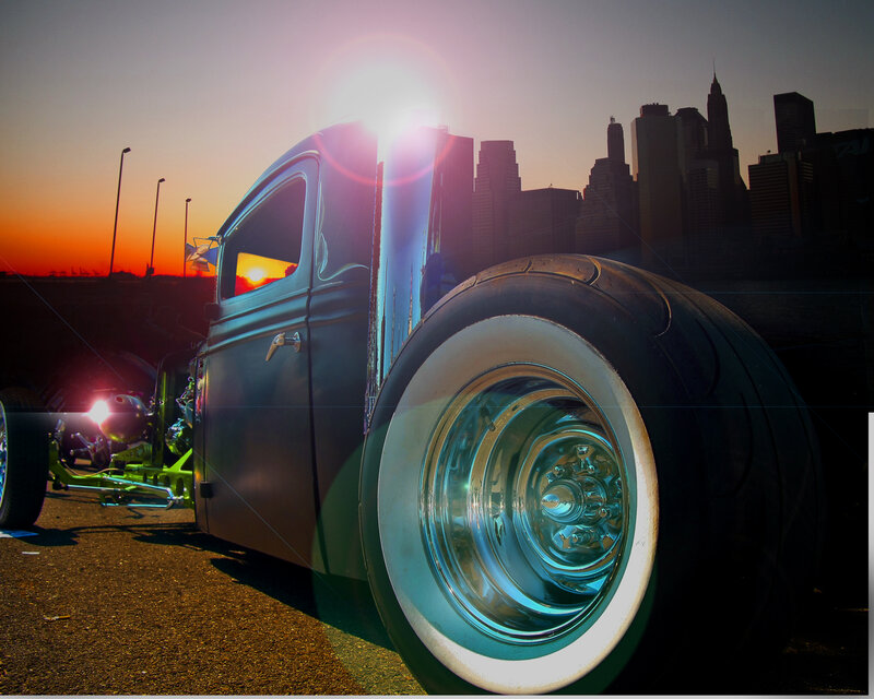 Hot rod at sunset with city skyline