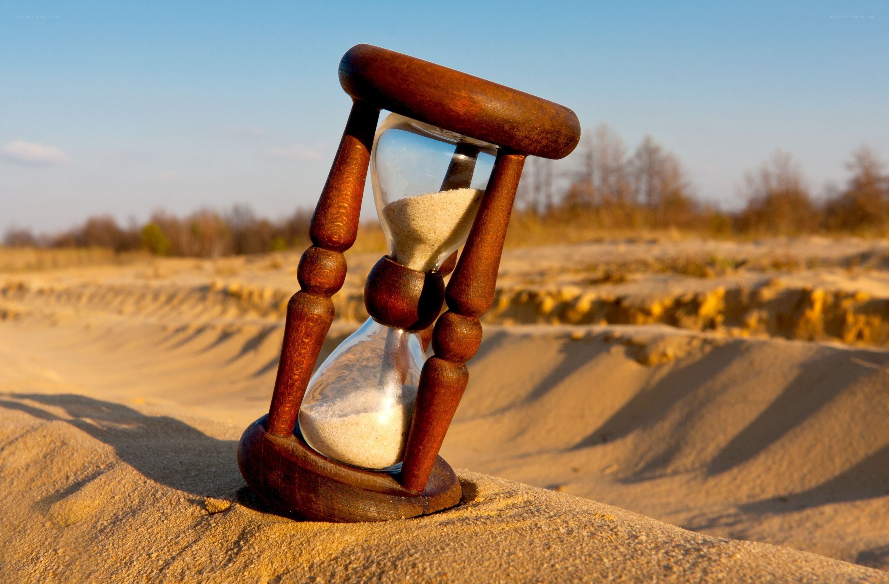 Hourglass on sandy dune