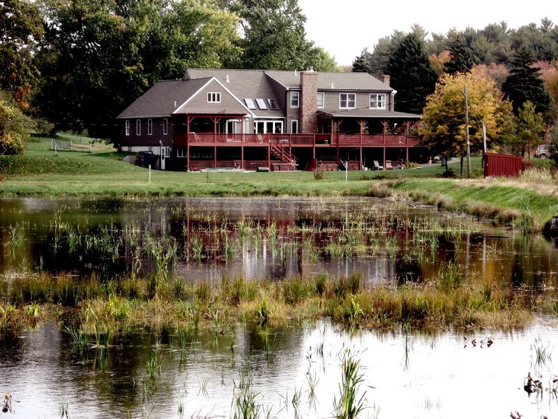 House by a pond with autumn trees