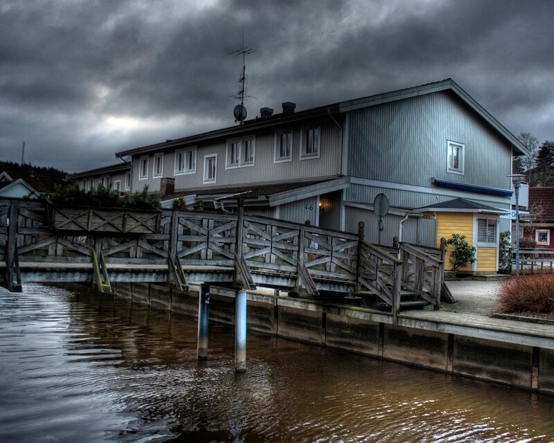 House by the water under stormy sky