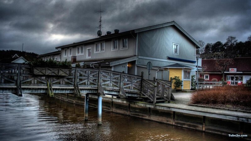 House by the water under stormy sky
