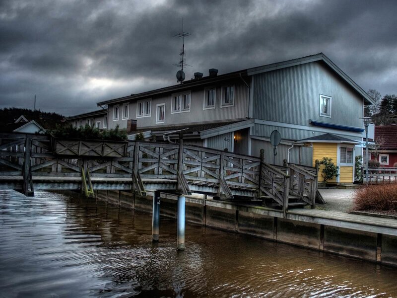 House by the water under stormy sky