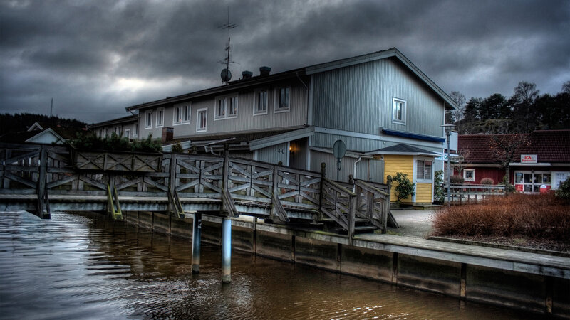 House by the water under stormy sky