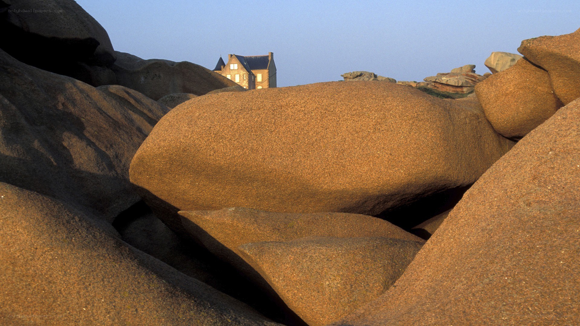 House on rocky coast at sunset