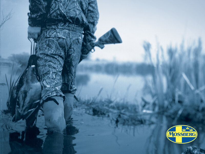 Hunter with ducks in marsh