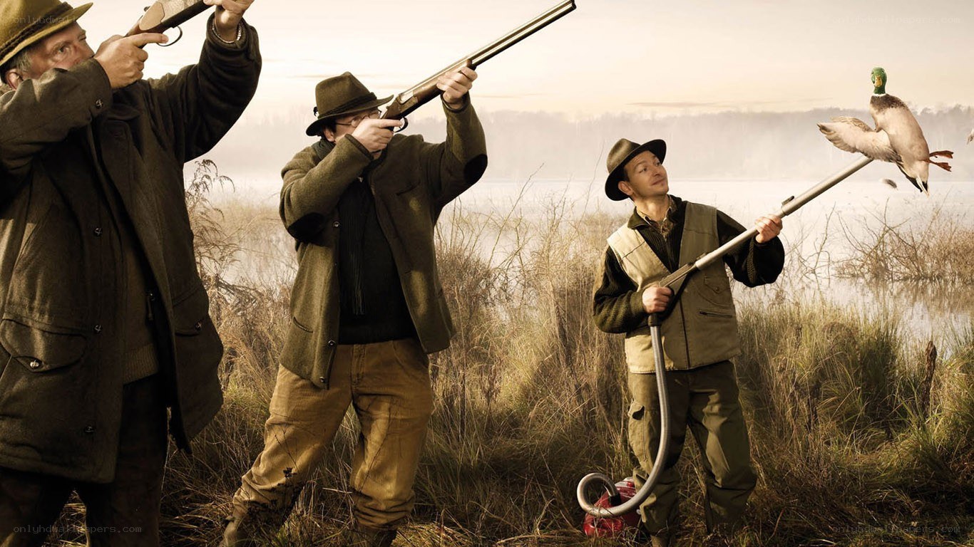 Hunters with shotguns in marsh