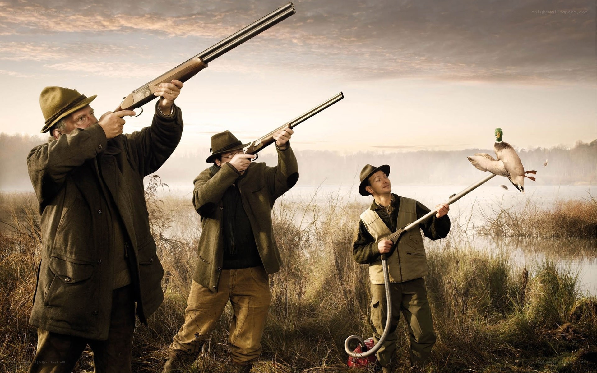 Hunters with shotguns in marsh