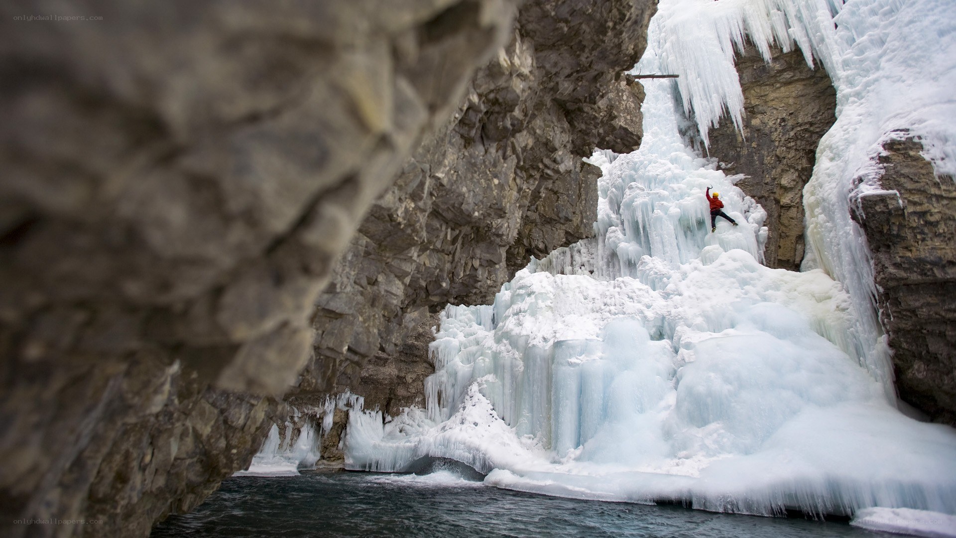 Ice climber on frozen waterfall