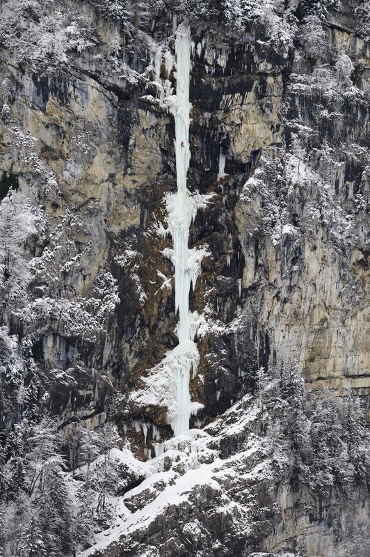 Ice climber on frozen waterfall