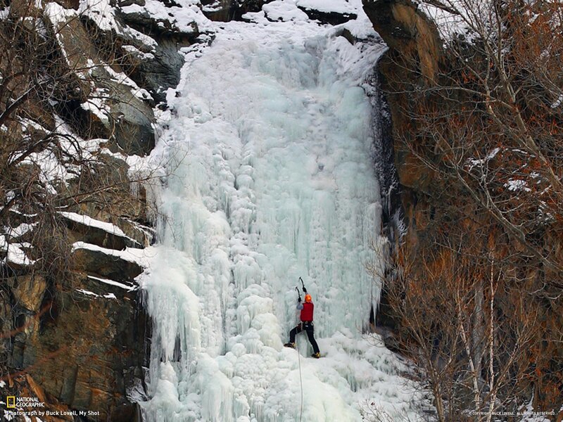 Ice climber on frozen waterfall