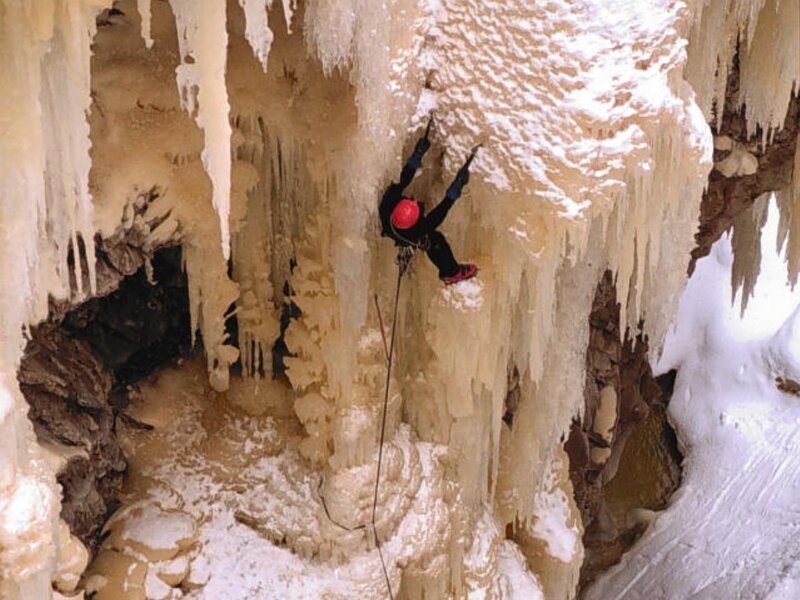 Ice climber scaling a frozen cave