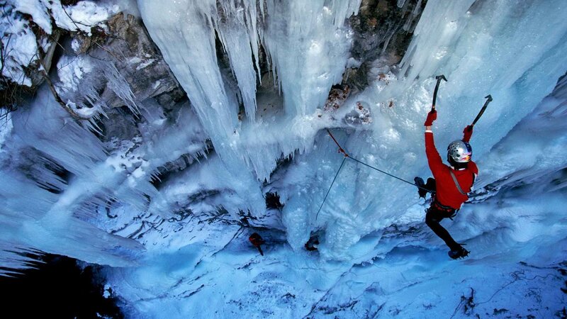Ice climber scaling frozen waterfall