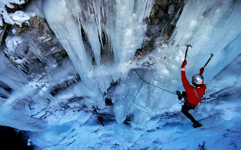 Ice climber scaling frozen waterfall