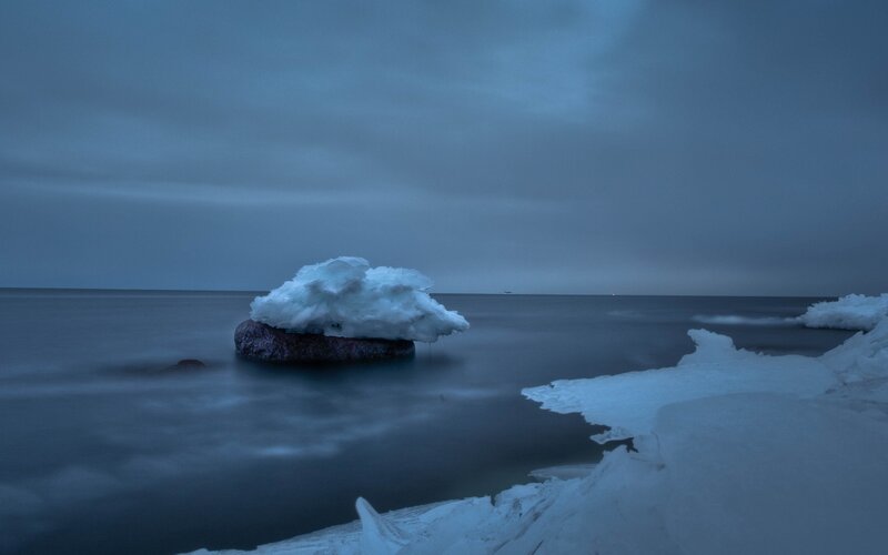 Ice-covered rock in calm sea
