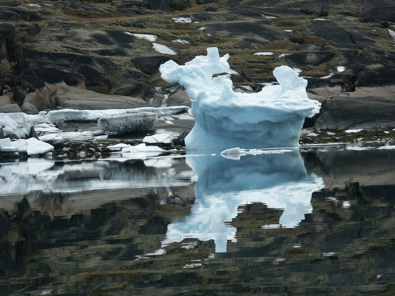 Iceberg in Calm Water — Blue, Serene, Photograph, Rocky Shore