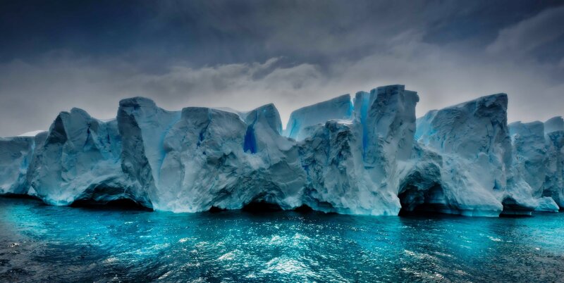 Iceberg in Ocean — Blue, Dramatic, Photograph, Sky, Clouds