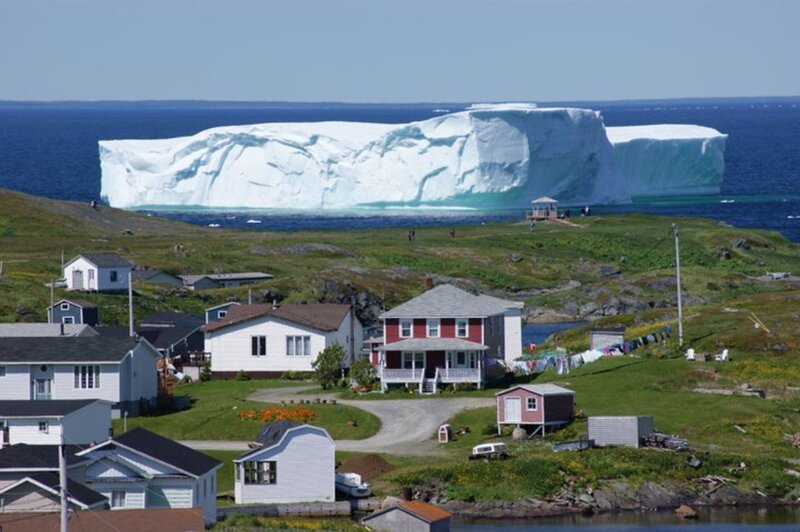 Iceberg Near Coastal Village