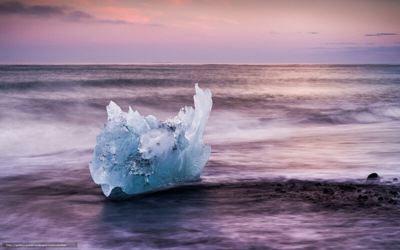 Iceberg on a beach at sunset