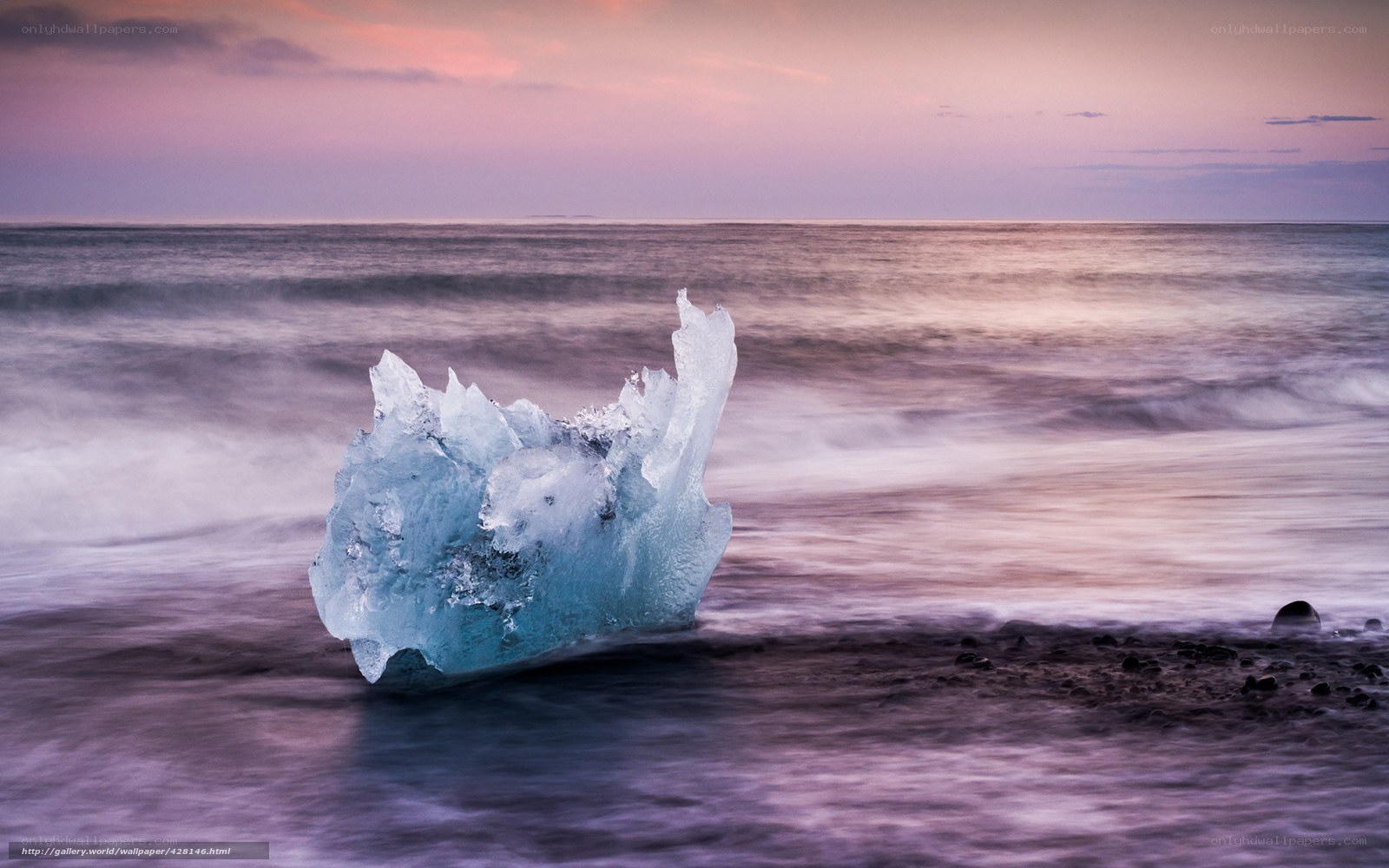 Iceberg on a beach at sunset