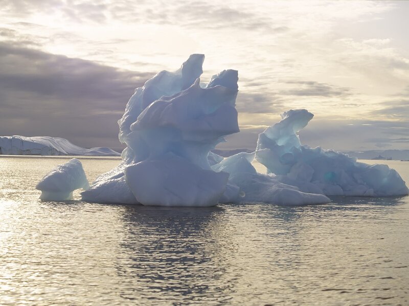 Icebergs in Calm Water — White, Serene, Sunset
