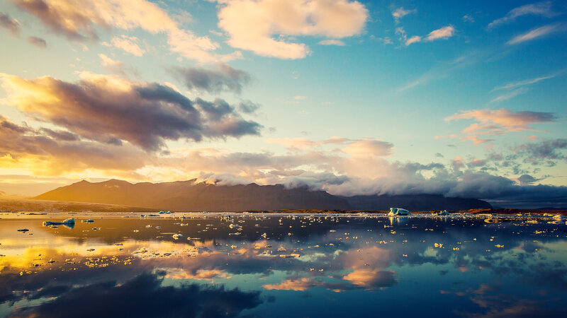 Icebergs in Glacial Lagoon — Blue, Serene, Sunset, Photograph, Mountains, Clouds