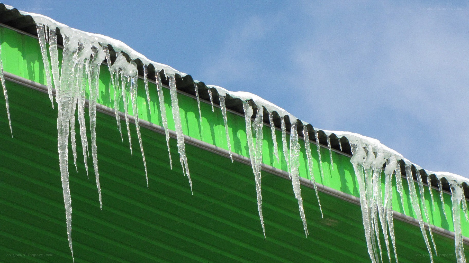 Icicles hanging from a green roof