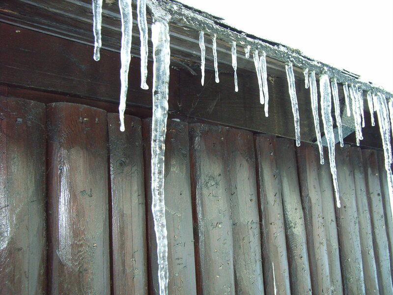 Icicles hanging from a wooden fence