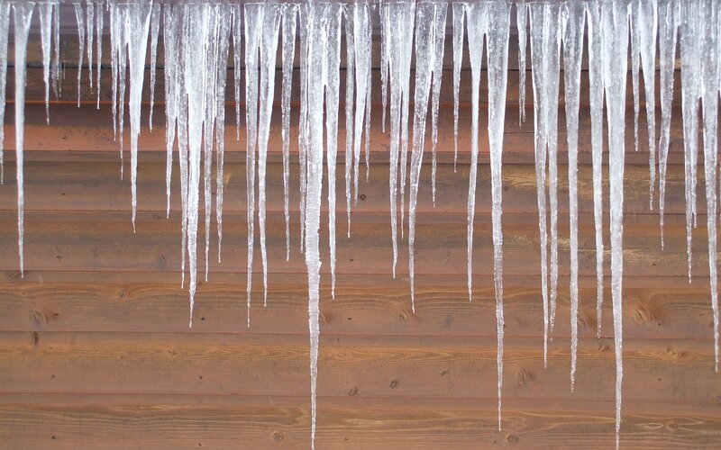 Icicles hanging from a wooden wall