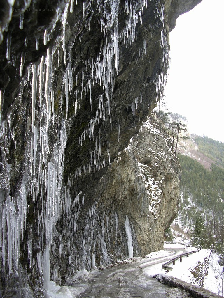 Icy cliff overhanging mountain road