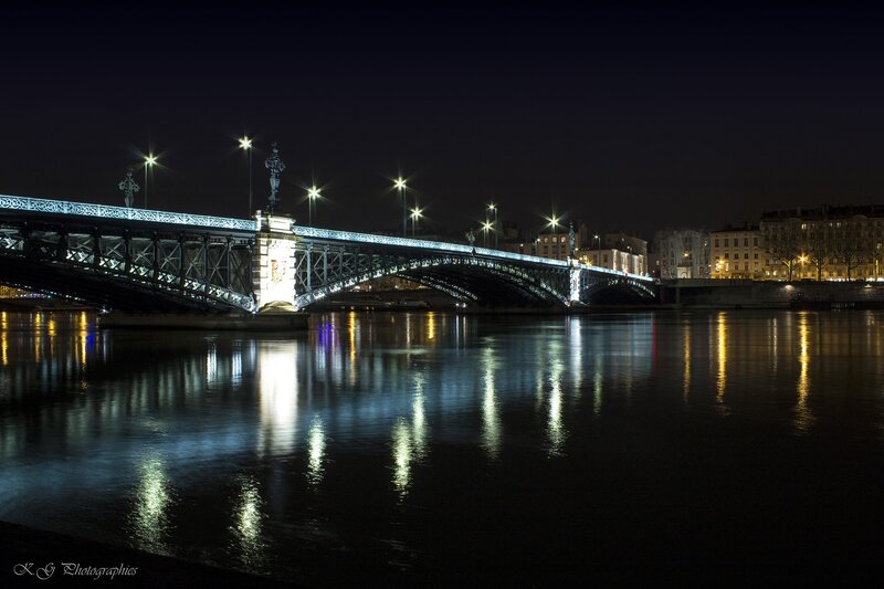 Illuminated Bridge at Night — Black, Serene, Photograph, River, City Buildings