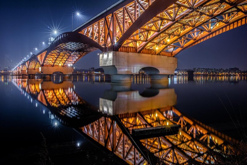 Illuminated Bridge at Night — Blue, Serene, Photograph, River, City Lights