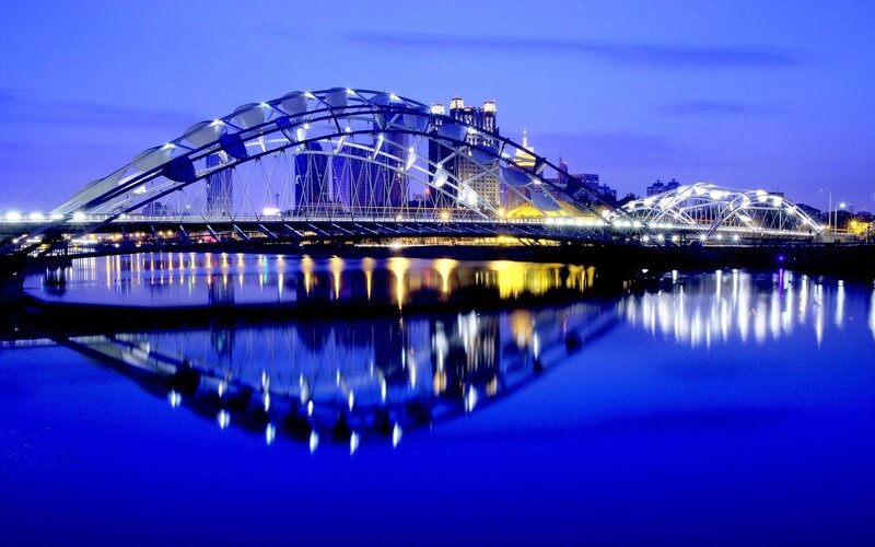 Illuminated Bridge at Night — Blue, Serene, Photograph, River, City Skyline, Reflection, Yellow