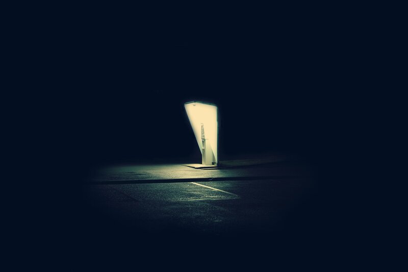 illuminated kiosk in dark parking lot