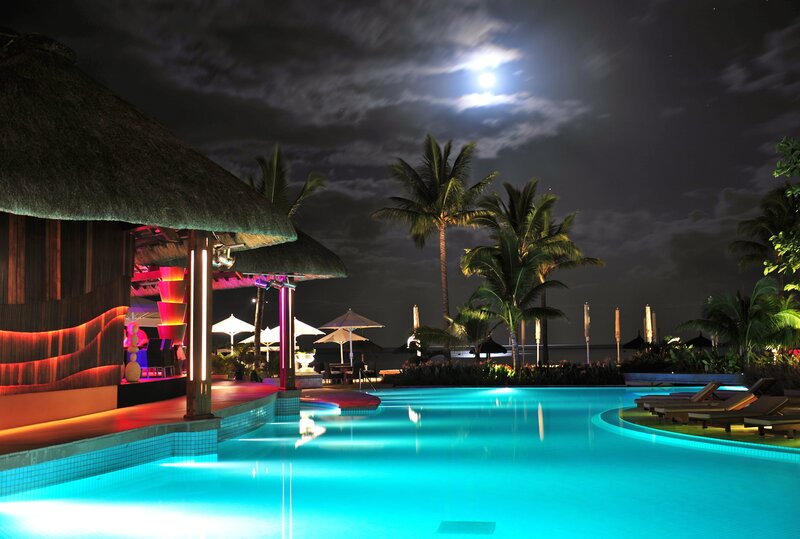 Illuminated Pool at Night — Blue, Serene, Photograph, Palm Trees, Thatched Roof