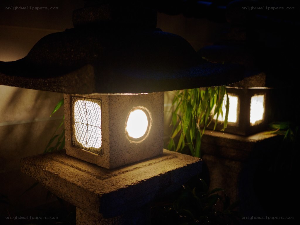 Illuminated stone lanterns at night