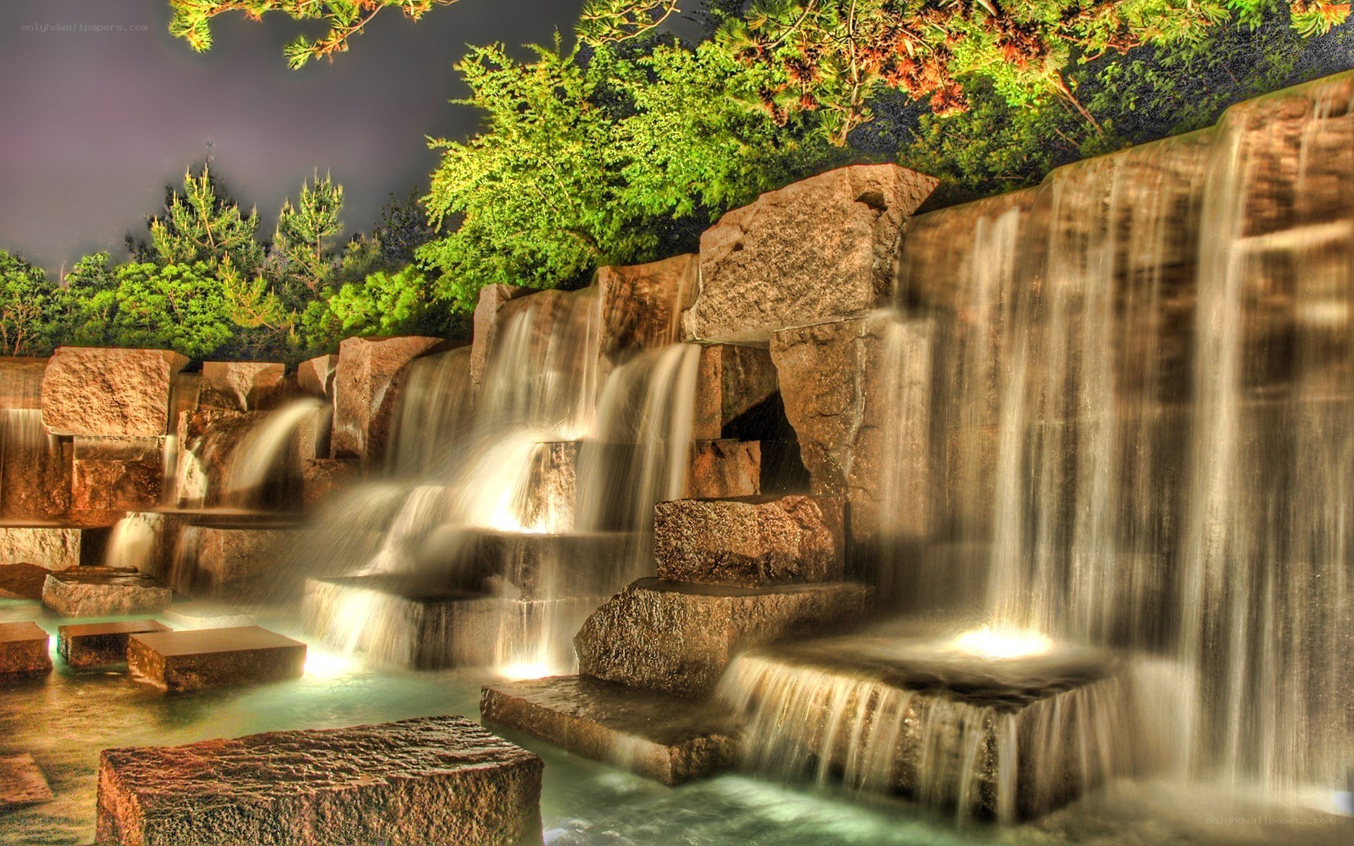Illuminated stone waterfall at night