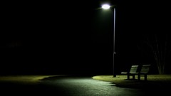 Lonely nighttime street lights park bench