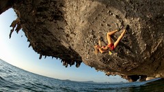 Sea rock woman climbing upside down swimsuits wide-angle