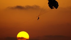 Sunset silhouettes skyscapes parachuting