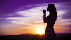 Sunset woman silhouettes blowing bubbles