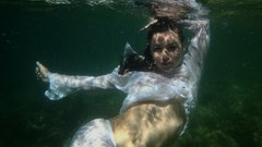 Woman underwater swimming white dress models black hair 