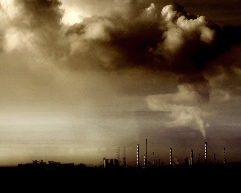 Industrial skyline under smoky sky
