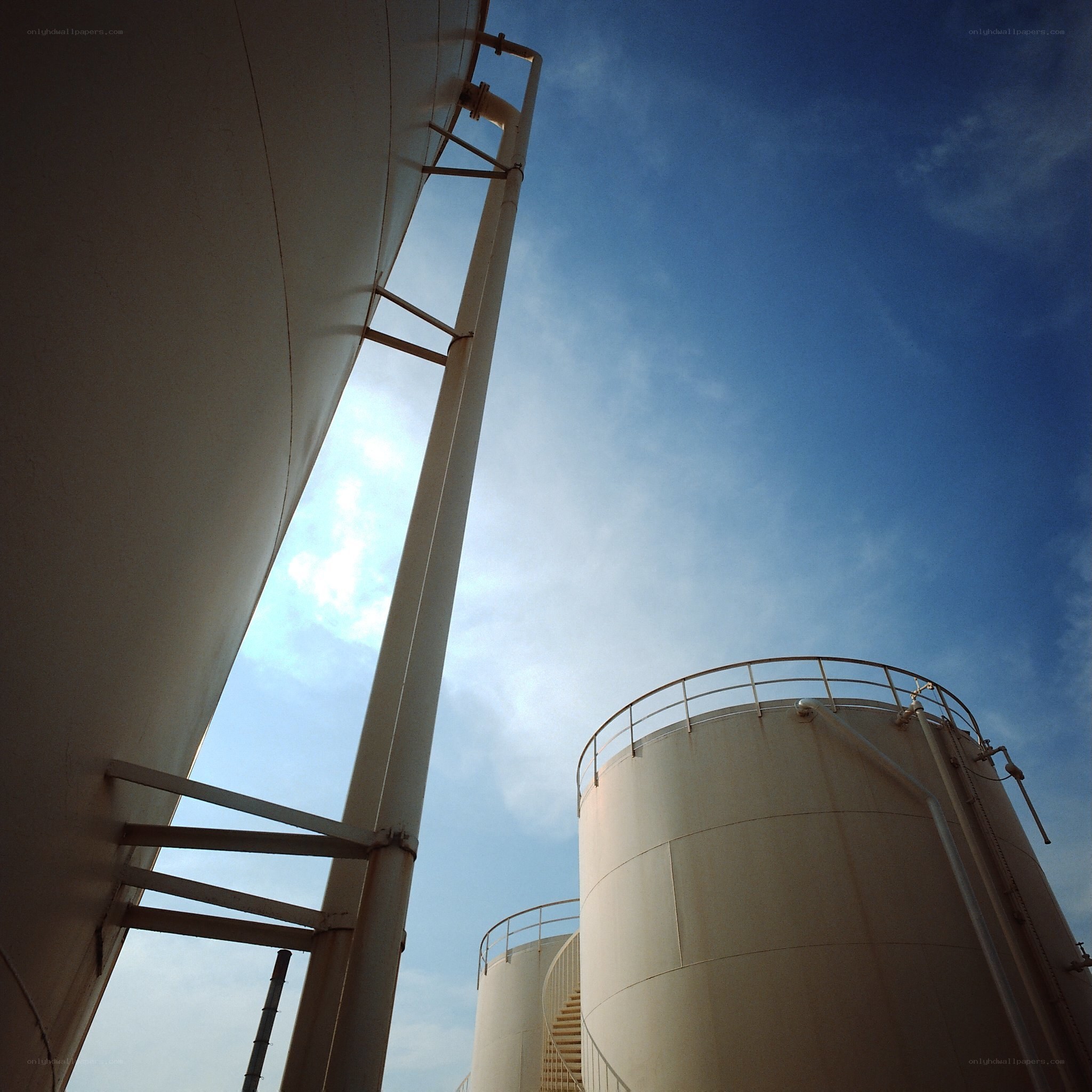 Industrial storage tanks under blue sky