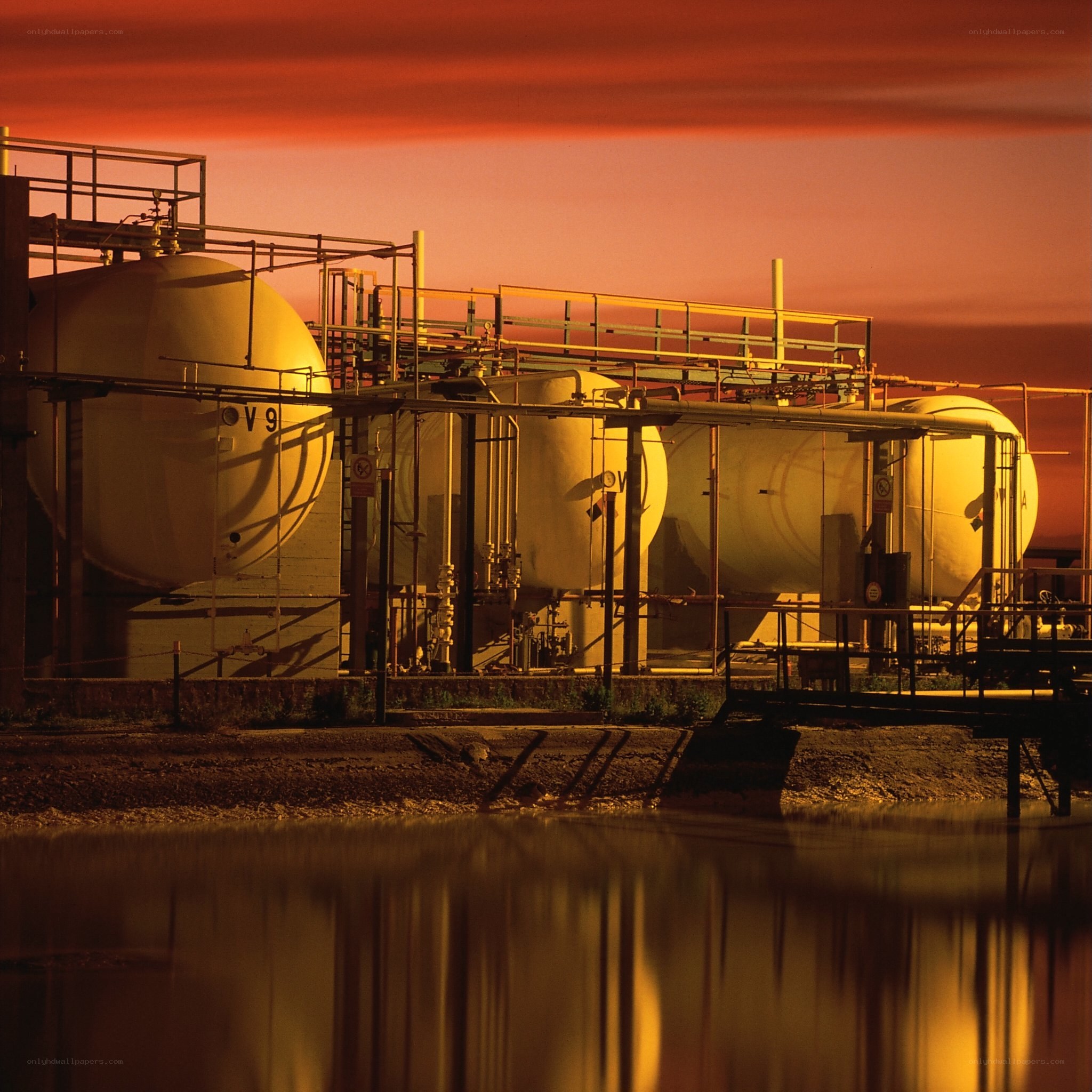 Industrial tanks at sunset