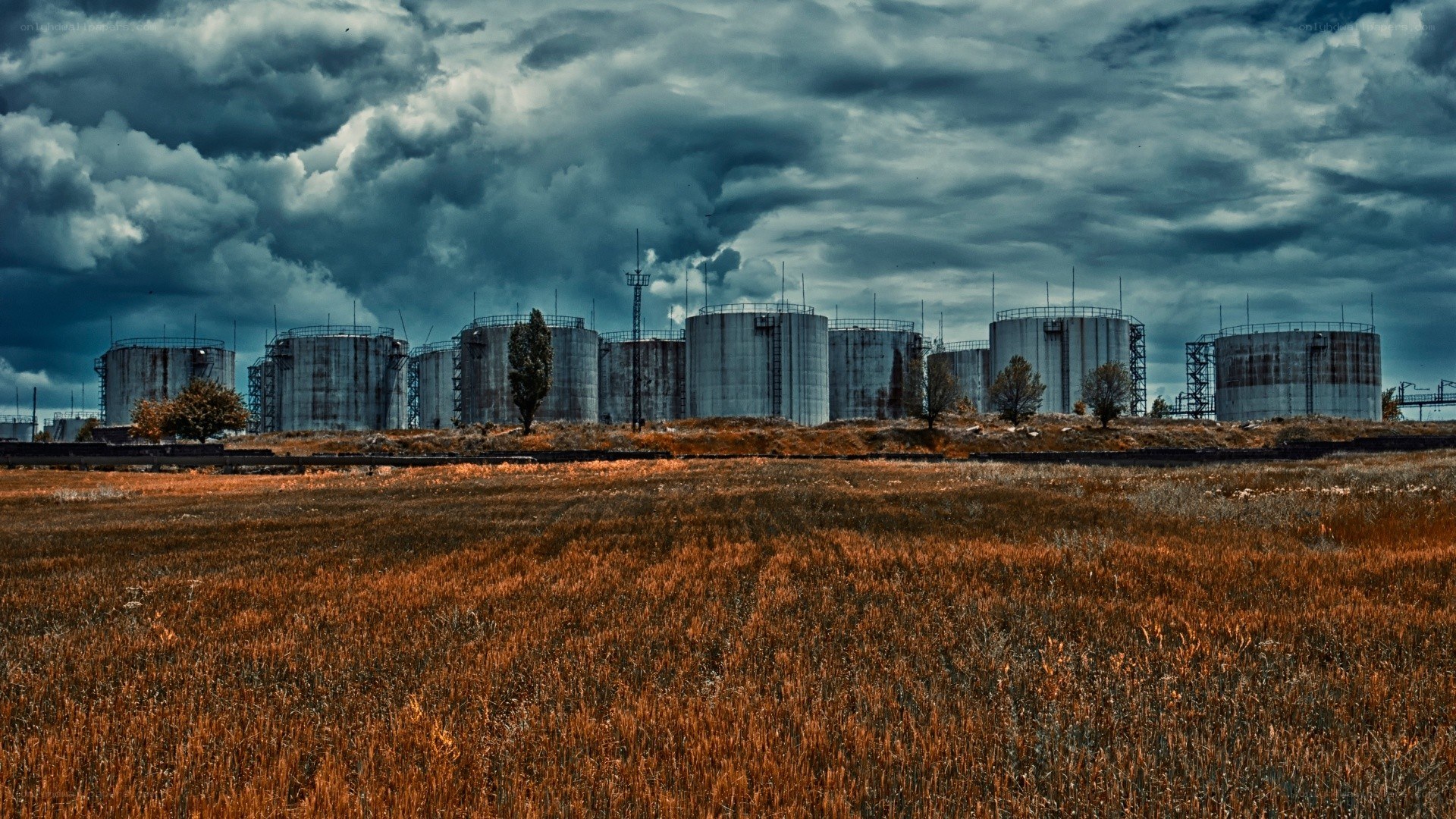 Industrial tanks under stormy sky